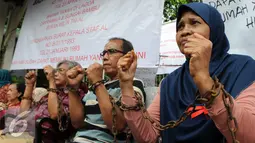 Sejumlah warga para sesepuh veteran mengikat tangannya dengan rantai di kawasan sungai bambu, Jakarta Utara, Rabu (3/2). Dalam aksi mereka menolak pengosongan rumah negara secara paksa terhadap 6 rumah negara. (Liputan6.com/Helmi Afandi)