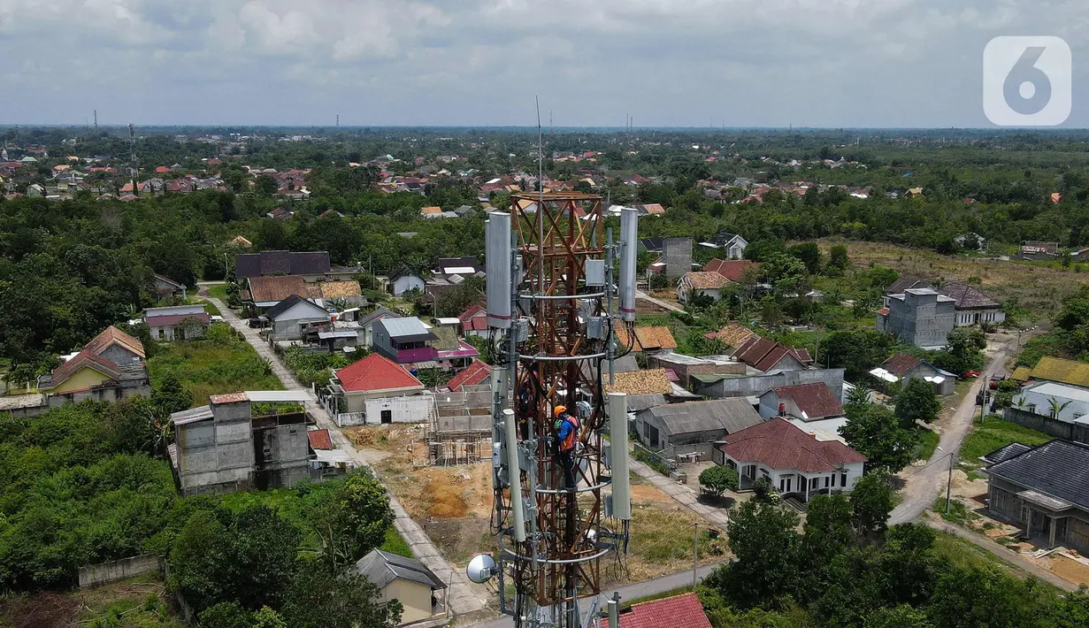 Foto udara teknisi melakukan pemeliharaan tower BTS 4G XL Axiata di Kuta Raya, Kayu Agung, Ogan Komering Ilir (OKI), Sumatera Selatan. Senin (13/3/2023). XL Axiata memastikan jaringan miliknya siap melayani kebutuhan pelanggan dan masyarakat selama Ramadhan hingga Hari Raya Idul Fitri 1444 Hijriah. (Liputan6.com/Herman Zakharia)