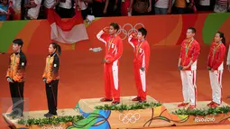 Pasangan ganda campuran Indonesia, Tontowi Ahmad dan Liliyana Natsir berdiri di atas podium saat menyanyikan lagu Indonesia Raya dan meraih medali usai laga final bulutangkis di Riocentro Pavilion 4, Brasil. (REUTERS/Mike Blake)