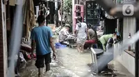 Warga beraktivitas di tengah banjir yang merendam permukiman warga di Kemang Timur XI, Jakarta, Minggu (21/2/2021). Warga berharap pemerintah segera memperbaiki longsor agar banjir tidak berkepanjangan. (merdeka.com/Iqbal S. Nugroho)