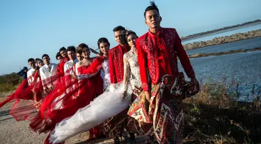 Model mengenakan busana kebaya bertema merah putih saat fashion show di tanggul Lapindo Porong, Sidoarjo, Jawa Timur, Selasa (13/8/2019). Peragaan busana yang menampilkan busana kebaya tersebut untuk memeriahkan HUT ke-74 kemerdekaan RI. (Photo by JUNI KRISWANTO / AFP)