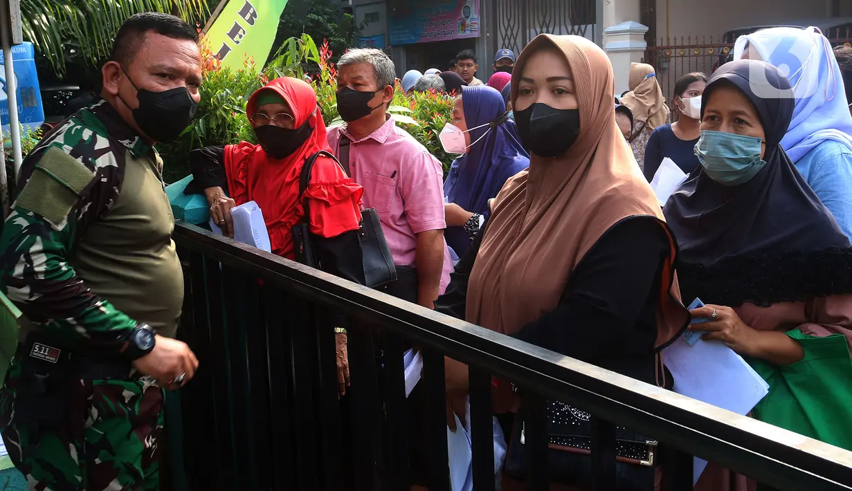 Sejumlah warga antre untuk mendapatkan Bantuan Langsung Tunai (BLT) minyak goreng di Koramil 02 Beji, Kota Depok, Jawa Barat, Kamis (19/5/2022). Pemerintah melalui TNI mendistribusikan BLT minyak goreng sebesar Rp300 ribu per orang untuk masyarakat penerima manfaat. (merdeka.com/Arie Basuki)