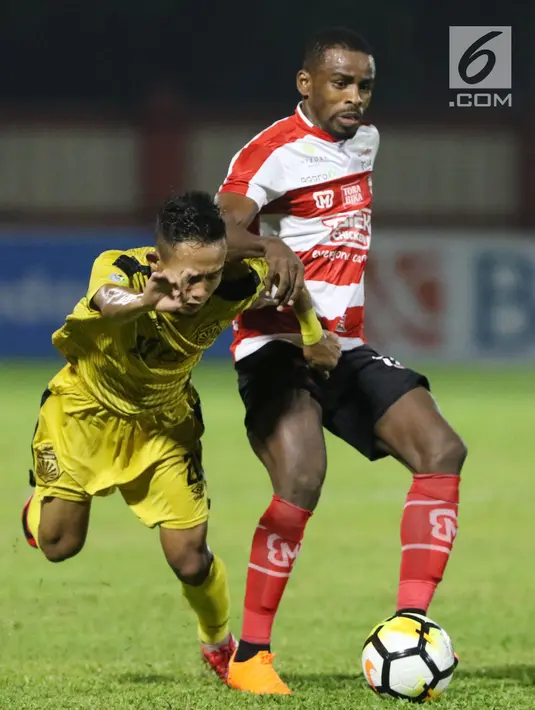 Pemain depan Madura United, Greg Nwokolo (kanan) menahan pergerakan pemain Bhayangkara FC pada lanjutan Go-Jek Liga 1 Indonesia 2018 bersama Bukalapak di Stadion PTIK, Jakarta, Kamis (7/6). Bhayangkara FC unggul 1-0. (Liputan6.com/Helmi Fithriansyah)