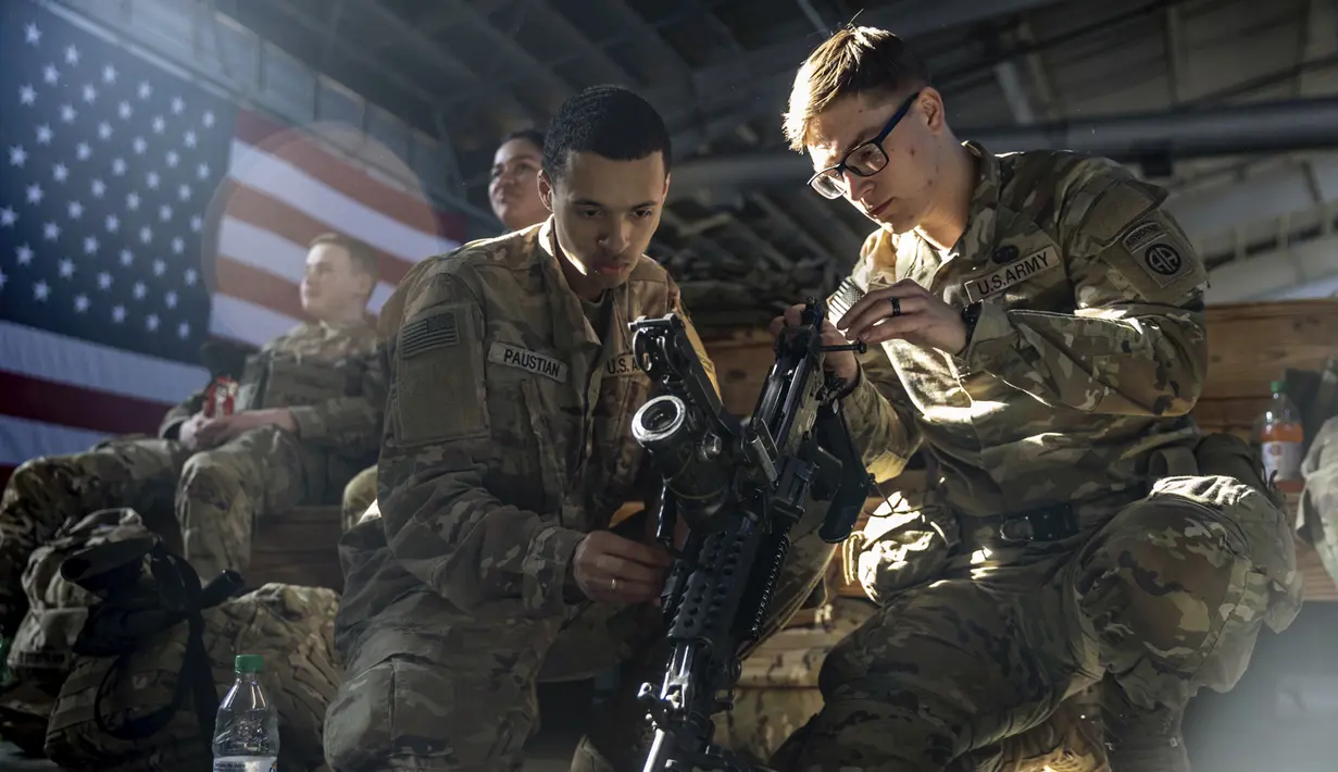 Anggota Divisi Lintas Udara ke-82 Angkatan Darat AS membersihkan persenjataan sebelum ditempatkan ke Polandia dari Fort Bragg, North Carolina, AS, 14 Februari 2022. Mereka termasuk di antara tentara AS yang dikirim untuk NATO karena khawatir Rusia akan menyerang Ukraina. (AP Photo/Nathan Posner)