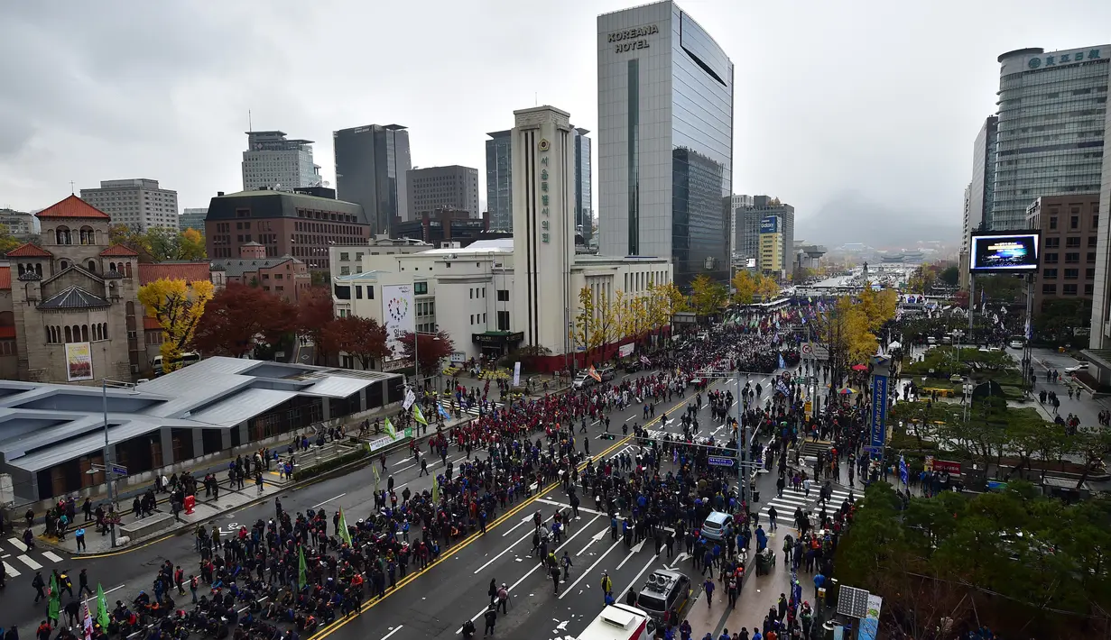 Ribuan orang membanjiri jalan-jalan di kota Seoul, Sabtu (14/11/2015). Mereka memprotes rencana pemerintah untuk mengadopsi buku pelajaran sejarah untuk siswa dan langkah-langkah mereformasi tenaga kerja. (AFP Photo/Jung Yeon)