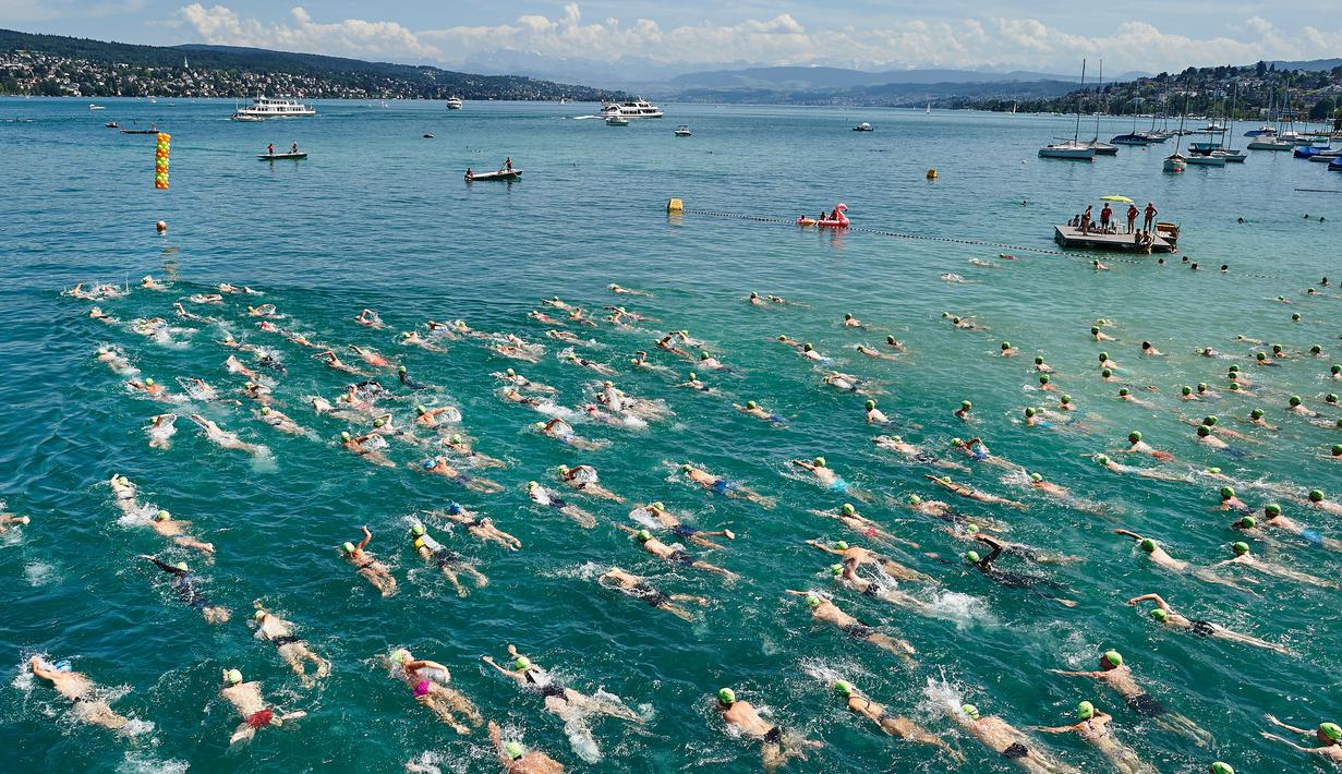 Aksi ratusan peserta menyeberangi Danau Zurich saat berpartisipasi dalam perhelatan tahunan di Swiss, 5 Juli 2017. Dalam ajang tersebut, ribuan orang harus bersaing mengarungi Danau Zurich sejauh 1,5 kilometer. (AFP PHOTO / Michael Buholzer)