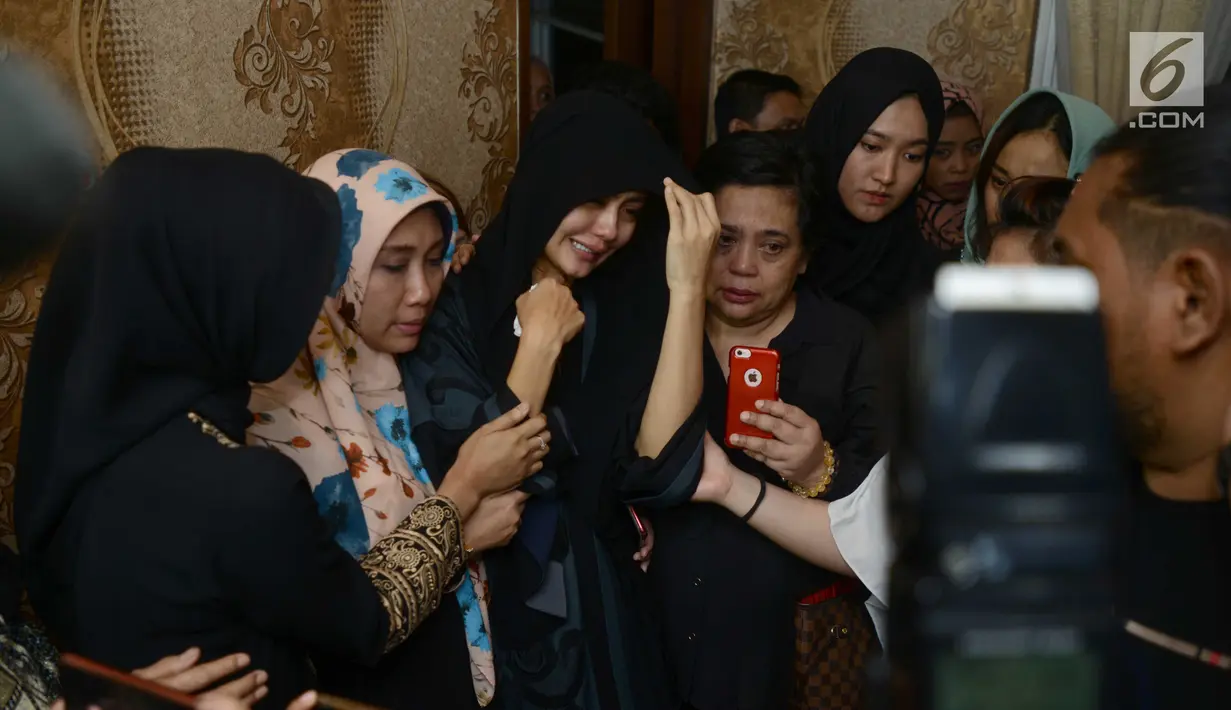 Istri gitaris grup band Seventeen Herman Sikumbang, Juliana Muhtar menangis saat menerima kedatangan jenazah suami di rumah duka di Pancoran, Jakarta Selatan, Senin (24/12). Herman dievakuasi langsung dari Tanjung Lesung. (Kapanlagi.com/Bayu Herdianto)