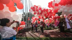 Sejumlah warga berfoto dengan balon berwarna merah putih yang menghiasi halaman Balai Kota, Jakarta, Senin (8/5). Balon-balon tersebut merupakan bentuk dukungan moril untuk Gubernur DKI Jakarta Basuki Tjahaja Purnama (Ahok). (Liputan6.com/Faizal Fanani)