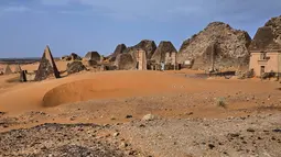 Seorang pengunjung berjalan diantara piramida Meroe di situs arkeologi Meroe di Bejrawiya, Sudan, Sabtu, 1 Agustus 2026. (Foto AP/Mohnd Blal)
