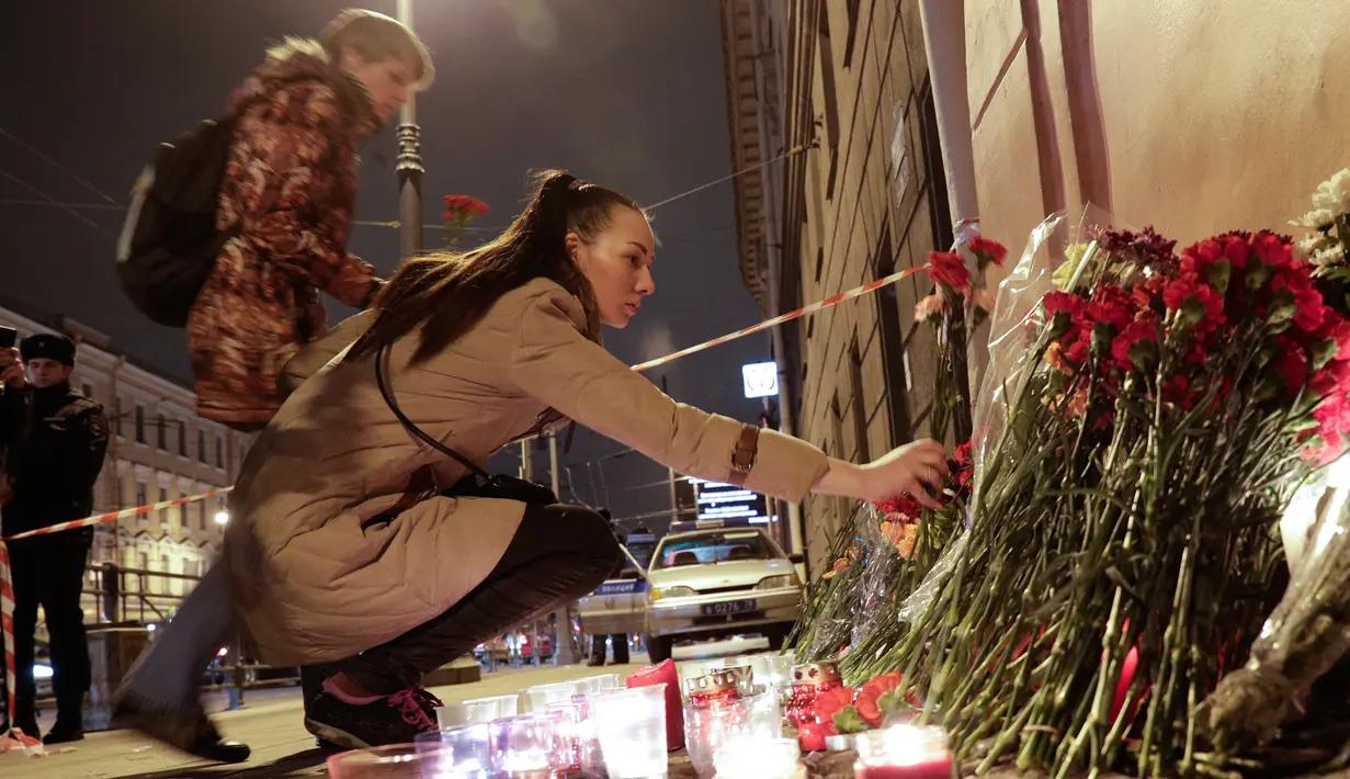Warga meletakan  karangan bunga di dekat lokasi ledakan bom di stasiun kereta bawah tanah St. Petersburg, Senin (3/4). Sampai saat ini penyebab ledakan masih samar. Belum ada kelompok yang mengklaim ledakan ini. (AP Photo / Dmitri Lovetsky)