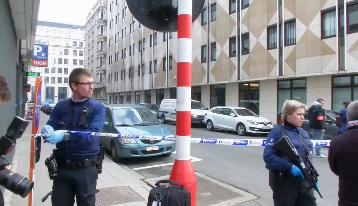 Petugas memasang garis polisi di luar stasiun metro Maalbeek, di Brussels, Belgia, setelah terjadi ledakan, Selasa (22/3).  Ledakan itu terjadi kurang dari satu jam setelah pengeboman di bandara yang menewaskan belasan orang. (REUTERS/Reuters TV)