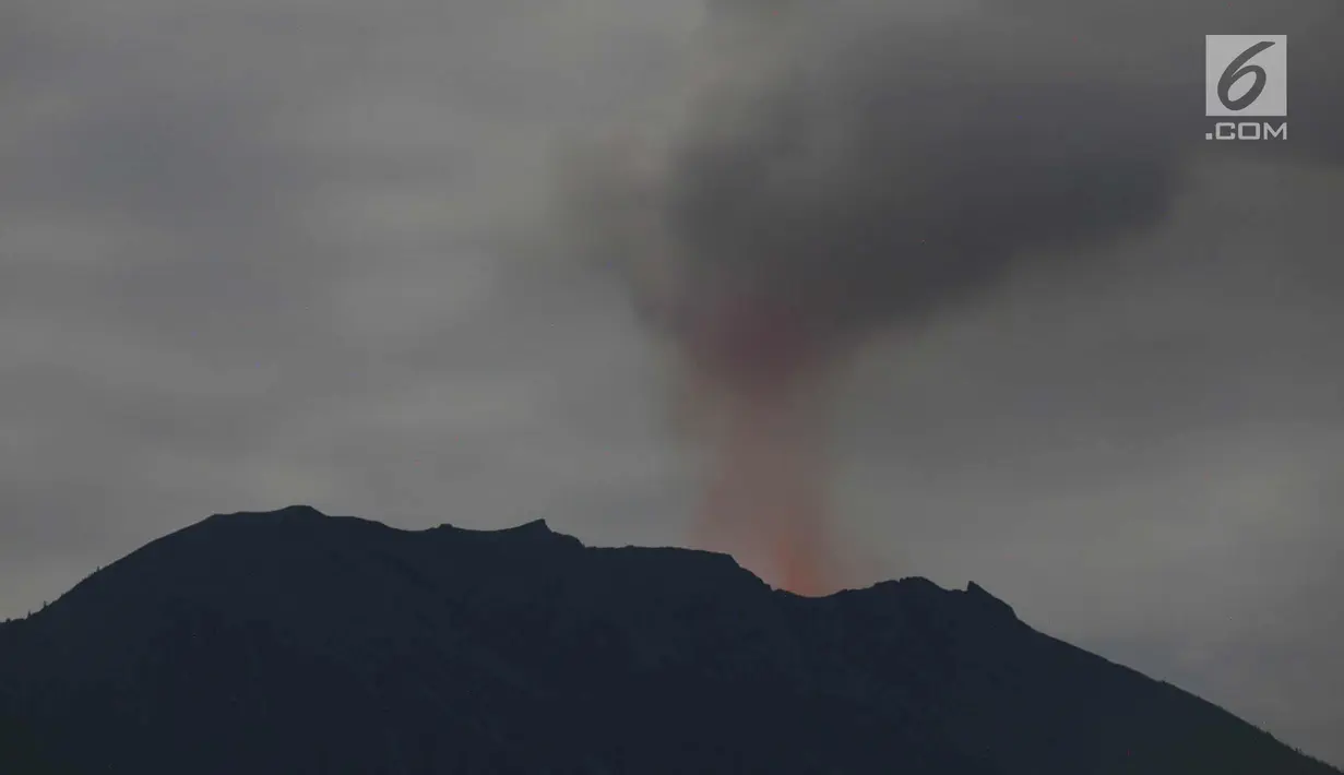 Asap yang disemburkan dari kawah Gunung Agung terlihat di Karang Asem, Bali (30/11). H+6 pasca erupsi, warna merah di puncak Gunung Agung mulai tampak samar, berbeda dengan beberapa hari sebelumnya. (Liputan6.com/Immanuel Antonius)