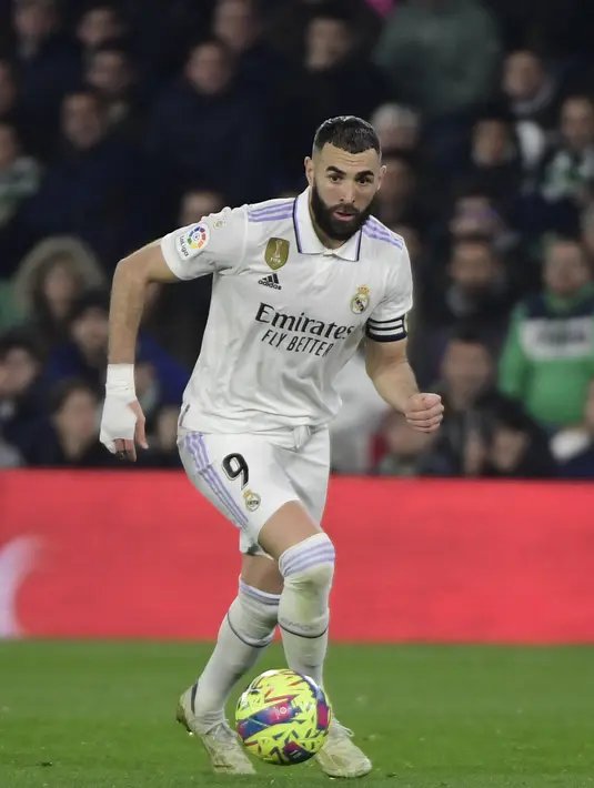 Penyerang Real Madrid, Karim Benzema membawa bola saat bertanding melawan Real Betis pada pertandingan La Liga Spanyol di stadion Benito Villamarin di Seville, Senin(6/3/2023). Hasil ini membuat Madrid tertahan di peringkat kedua LaLiga dengan 53 poin dari 24 pertandingan. (AFP/CRISTINA QUICLER)