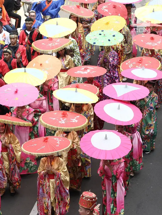 Peserta memakai kostum tradisional saat meramaikan pawai obor Asian Para Games 2018 di Jakarta, Minggu (30/9). Pawai obor dimulai dari Balai Kota DKI Jakarta dan berakhir di Gedung Kementerian Pemuda dan Olahraga. (Liputan6.com/Herman Zakahria)