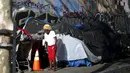 Seorang wanita keluar dari salah satu tenda yang ditempati kaum tunawisma di Skid Row, Los Angeles, California, Kamis (1/10/2015). Kota Los Angeles menetapkan status darurat terkait makin rumitnya persoalan kaum tunawisma di sana. (REUTERS/Lucy Nicholson)
