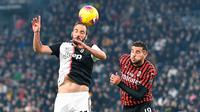 Striker Juventus, Gonzalo Higuain melompat saat berebut bola dengan pemain AC Milan Hernandez Theo pada pekan 12 Liga Italia 2019-2020 di Allianz Stadium, Minggu (10/11/2019).  Juventus semakin kokoh di puncak klasemen Liga Italia usai menundukkan AC Milan 1-0. (Alessandro Di Marco/ ANSA via AP)