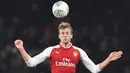 Bek Arsenal, Rob Holding berusaha mengontrol bola dengan kepalanya pada laga perempat final Piala Liga Inggris kontra West Ham United di Emirates Stadium, Selasa (20/12). Arsenal berhasil melaju ke babak semifinal setelah menang 1-0. (Ben STANSALL/AFP)