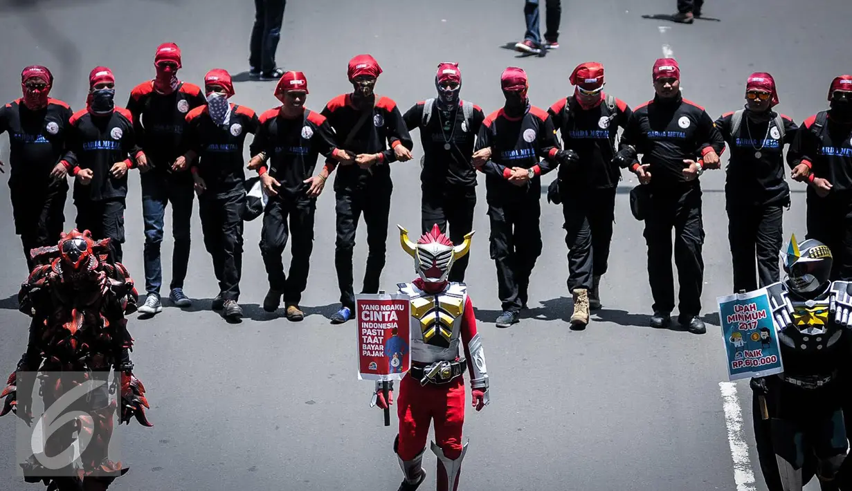 Para buruh mengenakan kostum cosplay super hero ketika berjalan menuju Istana Negara, Jakarta, Kamis (29/9). Dalam aksinya, buruh menuntut kenaikan upah mininum Rp 650ribu dan penghapusan Tax Amnesty. (Liputan6.com/Faizal Fanani)