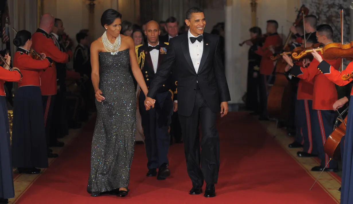 Presiden Amerika Serikat (AS) ke-44, Barack Obama menggandeng tangan sang istri, Michelle Obama, sambil berjalan menuju ruang timur Gedung Putih di Washington seusai makan malam bersama gubernur AS, 22 Februari 2009. (AFP PHOTO / MANDEL NGAN)