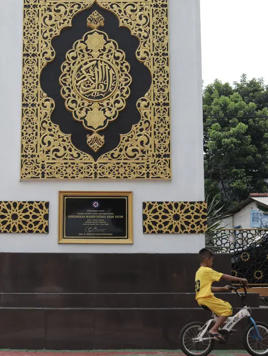 Seorang anak berada di dekat tugu Al-Quran di Masjid Istana Anak Yatim, Kabupaten Bogor, Jawa Barat, Jumat (30/4/2021). Tugu Al Quran yang dibangun ini mendapat penghargaan dari Leprid mencapai rekor dunia sebagai tugu Al Quran tertinggi di dunia. (Liputan6.com/Herman Zakharia)