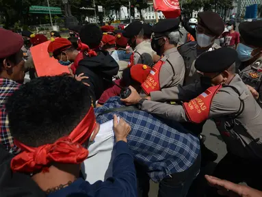 Massa gabungan dari berbagai elemen buruh dan organisasi mahasiswa terlibat aksi dorong dengan apparat kepolisian pada peringatan May Day di area Patung Kuda, Jakarta, Sabtu (1/5/2021). Polisi mengamankan sejumlah massa yang diduga mahasiswa dalam aksi unjuk rasa tersebut. (merdeka.com/Imam Buhori)