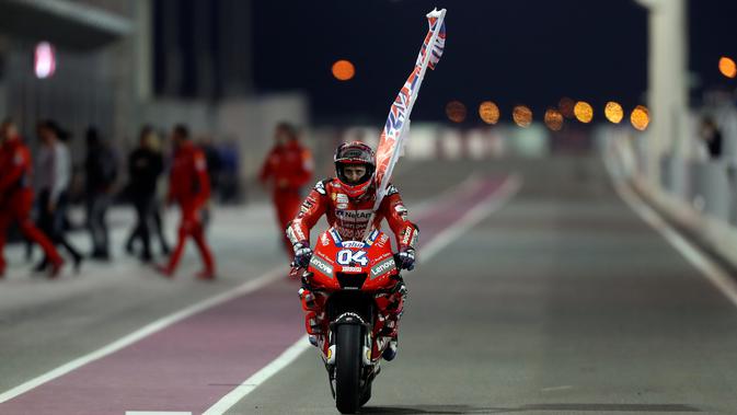 Pembalap Ducati, Andrea Dovizioso berselebrasi usai berhasil memenangkan seri pembuka MotoGP di Sirkuit Internasional Losail di Doha, Qatar (10/3). (AFP Photo/Karim Jaafar)