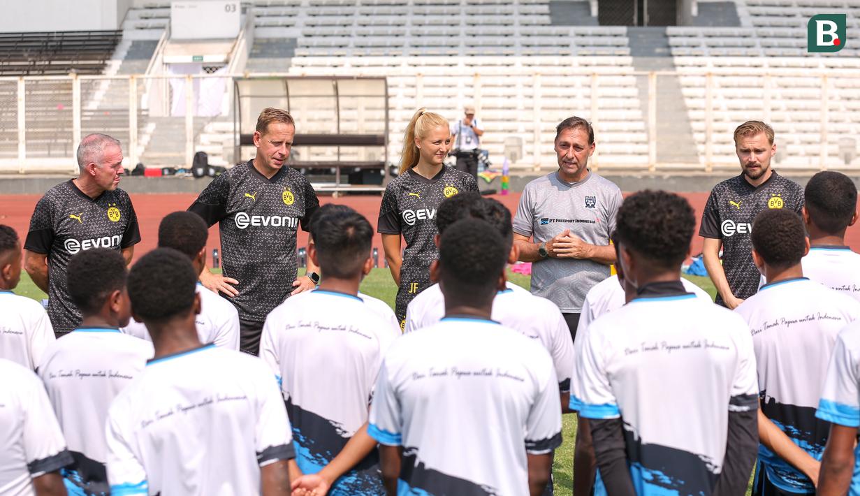 Direktur Papua Football Academy, Wofgang Pikal (kedua kanan) ditemani tiga legenda Borussia Dortmund, Paul Lambert (kiri), Joerg Heinrich (kedua kiri), dan Marcel Schmelzer (kanan) memberikan sambutan kepada peserta coaching clinic yang berlangsung di Stadion Madya, Senayan, Jakarta, Jumat (08/09/2023). (Bola.com/Bagaskara Lazuardi)