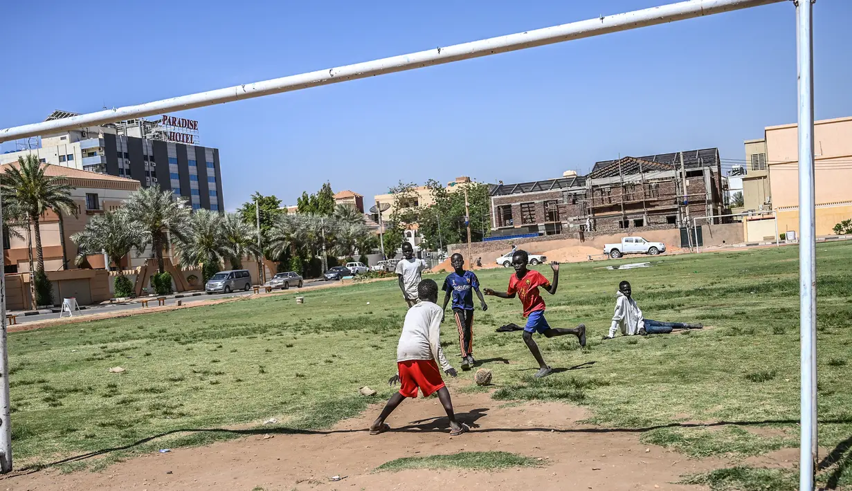 Seorang anak Sudan berusaha memasukan bola ke gawang saat bermain sepak bola di Khartoum (23/4). Khartoum didirikan pada tahun 1821 sebagai pos militer Mesir, namun berkembang menjadi pusat perdagangan regional. (AFP Photo/Ozan Kose)