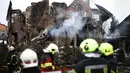 Para petugas penyelamat Ukraina berdiri di samping sebuah rumah yang rusak parah setelah serangan udara di Sofiivska Borshchagivka, wilayah Kyiv pada Minggu 22 Februari 2026. Rusia kembali melancarkan serangan besar-besaran menggunakan rudal dan pesawat nirawak (drone) ke wilayah pinggiran kota Kyiv. (Henry NICHOLLS/AFP)