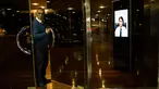 Seorang porter keluar dari pintu sebuah gedung di Buenos Aires, Argentina, Jumat (13/4). Argentina mulai menerapkan penjaga keamanan virtual di sujumlah gedung. (AP Photo/Rodrigo Abd)