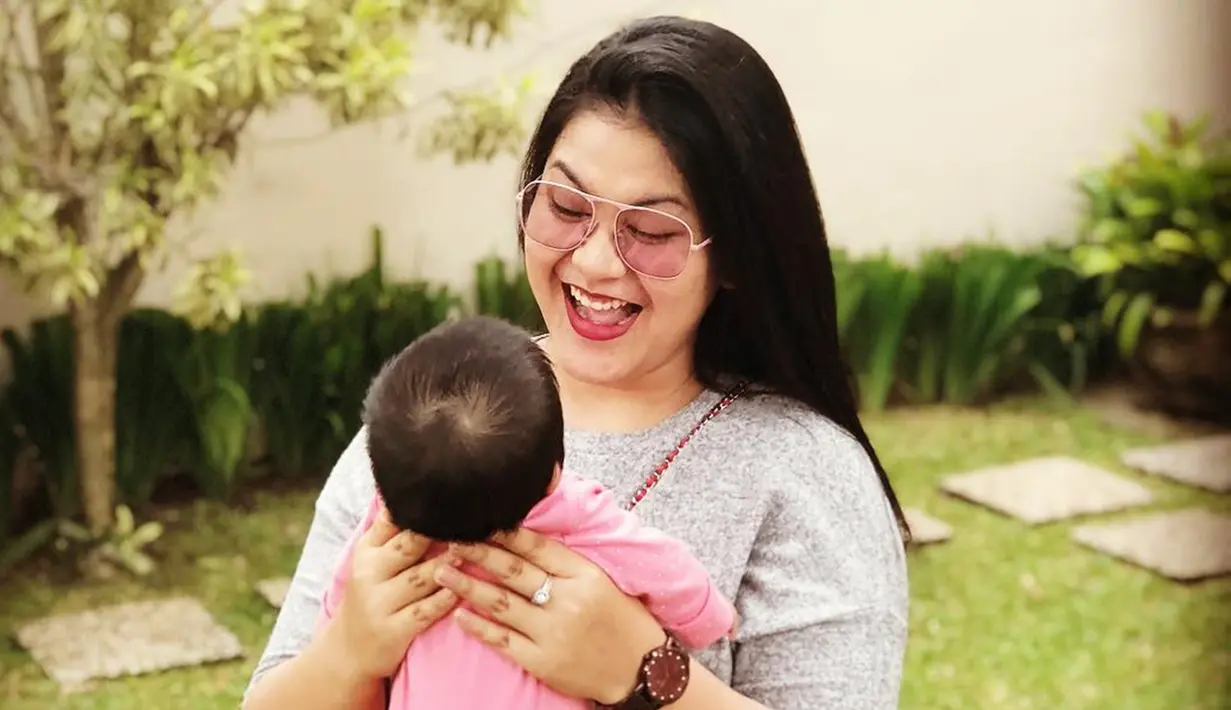 Bersantai dengan putri kesayangannya, Sedah Mirah. Istri Bobby Nasution memilih menggunakan lensa bewarna merah jambu dengan frame yang besar. Penampilan Kahiyang pun terlihat semakin ceria!(Liputan6.com/IG/@ayanggkahiyang)