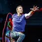 Aksi vokalis band Inggris Coldplay, Chris Martin saat tampil di The Stade de France Arena di Saint Denis, Paris, Prancis (15/7). (AFP Photo/Geoffroy Van Der Hasselt)