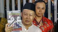 Mantan Kepala BPPN, Syafruddin Arsyad Temenggung menunjukkan buku yang ditulisnya saat meninggalkan Rutan KPK, Jakarta, Selasa (7/9/2019). Sebelumnya, Majelis Hakim Pengadilan Tipikor Jakarta menjatuhi vonis 13 tahun penjara dan denda Rp700 juta. (Liputan6.com/Helmi Fithriansyah)