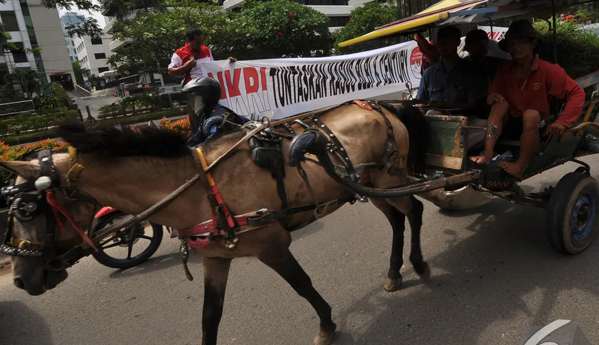 sebuah delman melintas di depan gedung KPK saat para pegiat anti korupsi melakukan aksi di Hari   Hari Anti Korupsi Sedunia, Jakarta, Selasa (9/12/2014). (Liputan6.com/Miftahul Hayat)