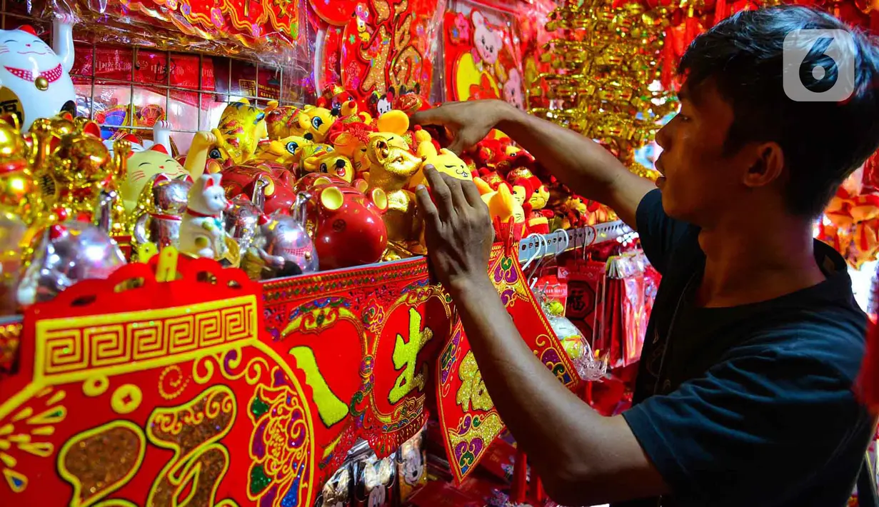 Pedagang  menata pernak-pernik Imlek yang dijual di kawasan Glodok, Jakarta, Senin (13/1/2020). Menyambut tahun baru Imlek pada 25 Januari mendatang, penjualan pernak-pernik imlek dijual dengan harga Rp 5ribu hingga jutaan rupiah per buah tergantung jenis. (merdeka.com/Arie Basuki)