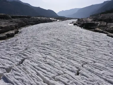 Pemandangan dari udara terlihat Sungai Kuning yang tertutup es di dekat tempat wisata Air Terjun Hukou di Provinsi Shaanxi, China pada 16 Desember 2020. Air terjun Hukou menyuguhkan pemandangan musim dingin nan spektakuler saat suhu udara terus turun dalam beberapa hari terakhir. (Xinhua/Tao Ming)