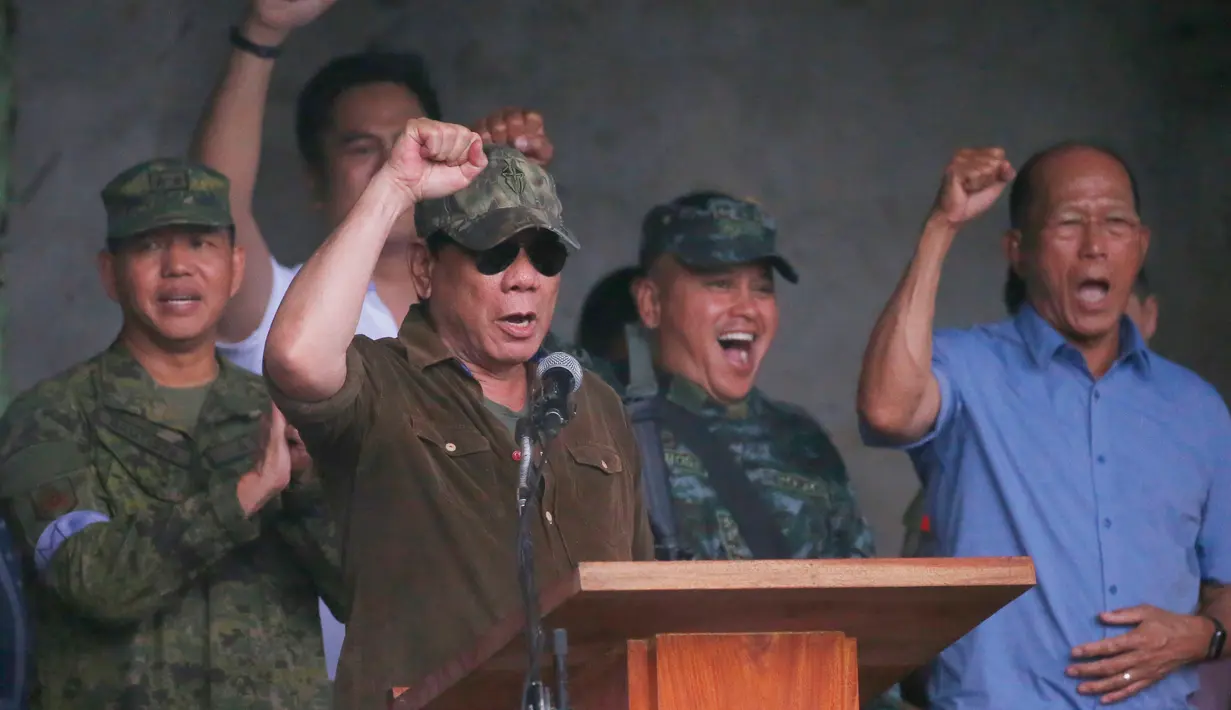 Presiden Filipina, Rodrigo Duterte bersorak saat mengumumkan pembebasan Kota Marawi di Filipina (17/10). Duterte mendeklarasikan Kota Marawi telah terbebas dari kelompok militan Maute yang berafiliasi dengan ISIS. (AP Photo/Bullit Marquez)
