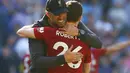 Jurgen Kloop berpelukan dengan Robertson usai pastikan kemenangan pada laga lanjutan Premier League yang berlangsung di Stadion Millenium, Cardiff, Minggu (21/4). Liverpool menang 2-0 atas Cardiff City. (AFP/Geoff Caddick)