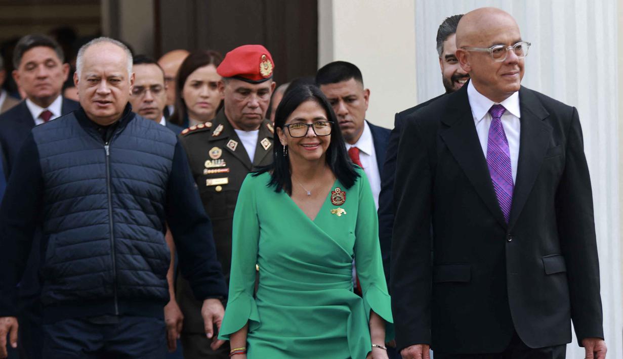 Pelantikan Delcy Rodriguez berlangsung di Majelis Nasional Venezuela. Tampak dalam foto yang dirilis oleh kantor pers Istana Miraflores ini menunjukkan Presiden sementara Venezuela, Delcy Rodriguez (tengah); Menteri Dalam Negeri Venezuela, Diosdado Cabello (kiri); dan Ketua Majelis Nasional Venezuela, Jorge Rodriguez (kanan), berjalan setelah mengucapkan sumpah dalam sebuah upacara di Majelis Nasional di Caracas pada 5 Januari 2026. (Foto oleh Marcelo Garcia/Kantor Pers Miraflores/AFP)