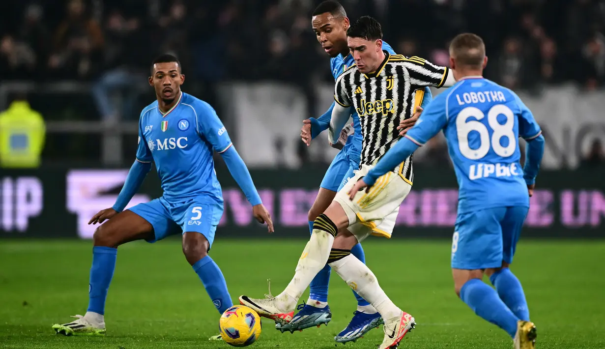 Pemain Juventus, Dusan Vlahovic (tengah), mengontrol bola dan berusaha melewati hadangan dua pemain Napoli dalam pertandingan pekan ke-15 Liga Italia 2023/2024 yang berlangsung di Allianz Stadium, Sabtu (9/12/2023) dini hari WIB. (AFP/Marco Bertorello)