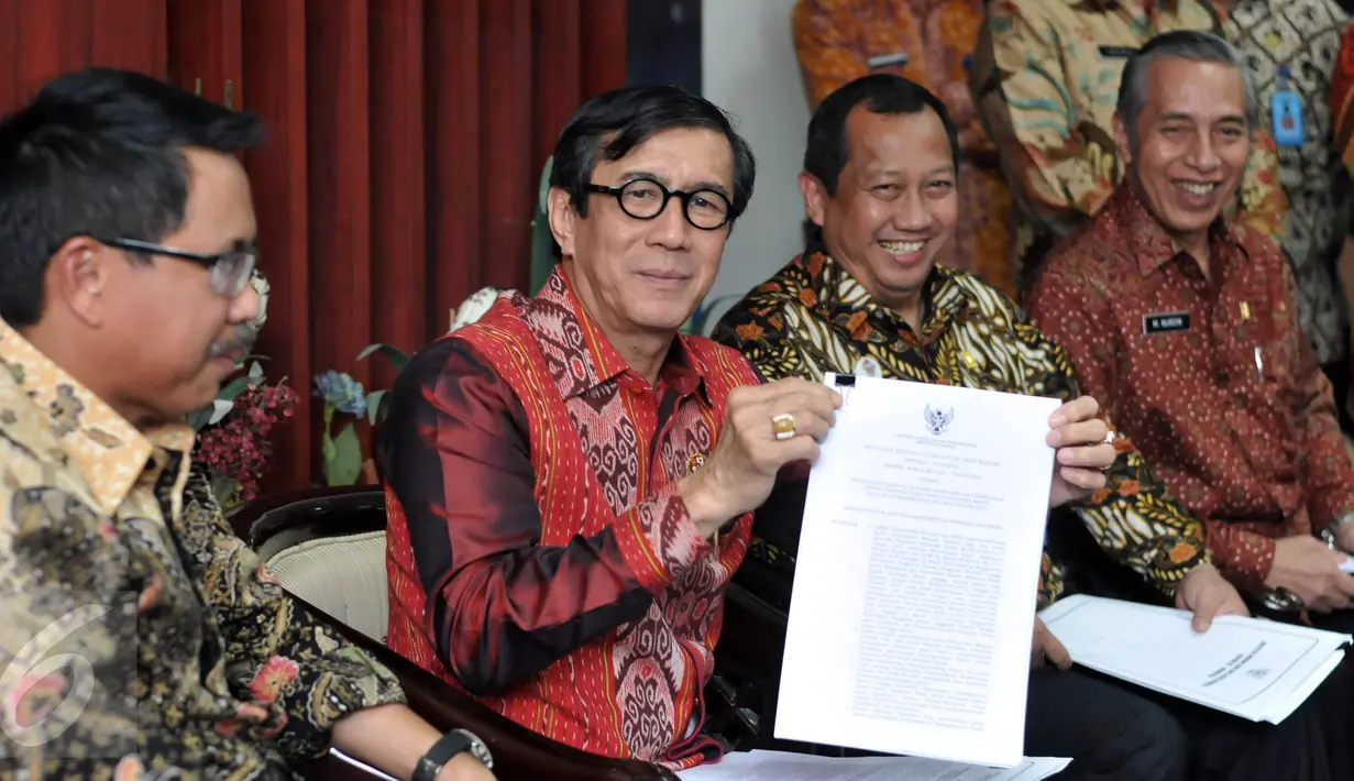 Menkumham Yasonna Laoly (kedua kiri) menunjukan surat pengaktifan kembali kepengurusan Golkar Munas Riau, Jakarta, Kamis (28/1/2016). SK Kepengurusan Partai Golkar Munas Riau diaktifkan untuk 6 bulan ke depan. (Liputan6.com/Johan Tallo)