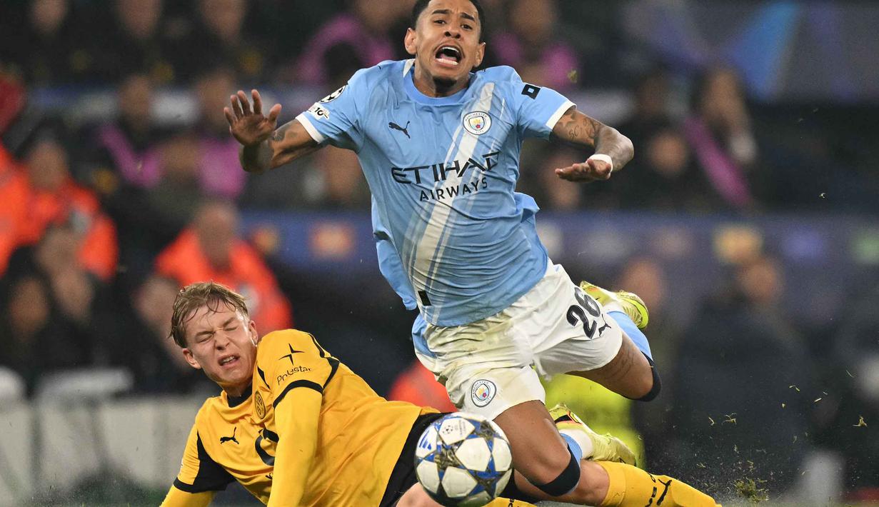 Di babak kedua, dominasi City semakin tak terbendung. Tampak dalam foto, bek Dortmund asal Swedia, Daniel Svensson mengadang gelandang Manchester City asal Brasil Savinho dalam pertandingan lanjutan fase liga Liga Champions 2025/2026 antara Manchester City dan Borussia Dortmund di Stadion Etihad, Manchester, Inggris barat laut, pada 5 November 2025 waktu setempat atau Kamis (6/11) dini hari WIB. (Oli SCARFF/AFP)