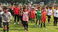 Andi Yanuar Pribadi (kaos merah) dan Suswanto di tengah-tengah siswa SSB peserta Liga Mandiri 2022 di Kediri. (Bola.com/Gatot Susetyo)