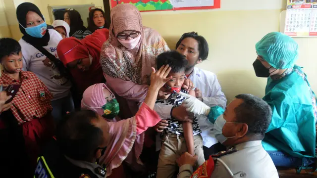 FOTO: Polisi Bantu Tenangkan Siswa SLB yang Disuntik Vaksin COVID-19