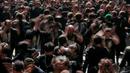 Dengan mengenakan pakaian berwarna hitam yang sengaja dikotori dan dikoyak, rombongan umat Syiah serentak memukul dada. (AP Photo/Anmar Khalil)
