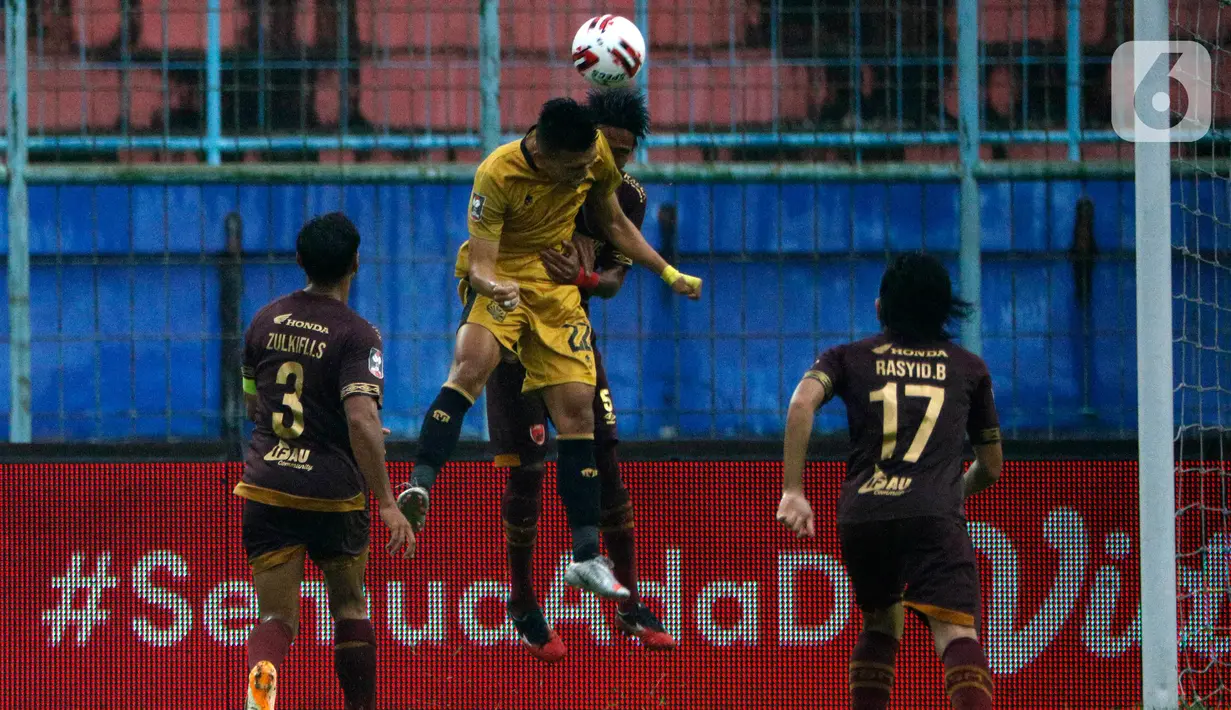 Pemain Bhayangkara Solo FC, Indra Kahfi (dua kiri) berebut bola udara dengan pemain PSM Makassar, Erwin Gutawa dalam pertandingan Penyisihan Grup B Piala Menpora 2021 di Stadion Kanjuruhan, Malang. Sabtu (27/3/2021). PSM Makassar bermain imbang atas Bhayangkara Solo FC 1-1. (Bola.com/Ikhwan Yanuar)