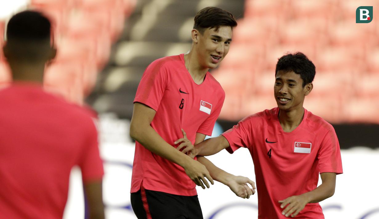 Pemain Singapura, Jacob Mahler, bercanda dengan Nazrul Nazari, saat latihan jelang laga Piala AFF 2018 di Stadion Nasional, Singapura, Kamis (8/11). Singapura akan melawan Timnas Indonesia. (Bola.com/M. Iqbal Ichsan)