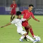 Pemain Timnas Indonesia U-19, Beckham Putra Nugraha (kanan) berebut bola dengan pemain Timor Leste pada laga kualifikasi Grup K Piala AFC U-19 2020 di Stadion Madya Gelora Bung Karno, Jakarta, Rabu (6/11/2019). Indonesia unggul 3-1. (Liputan6.com/Helmi Fithriansyah)