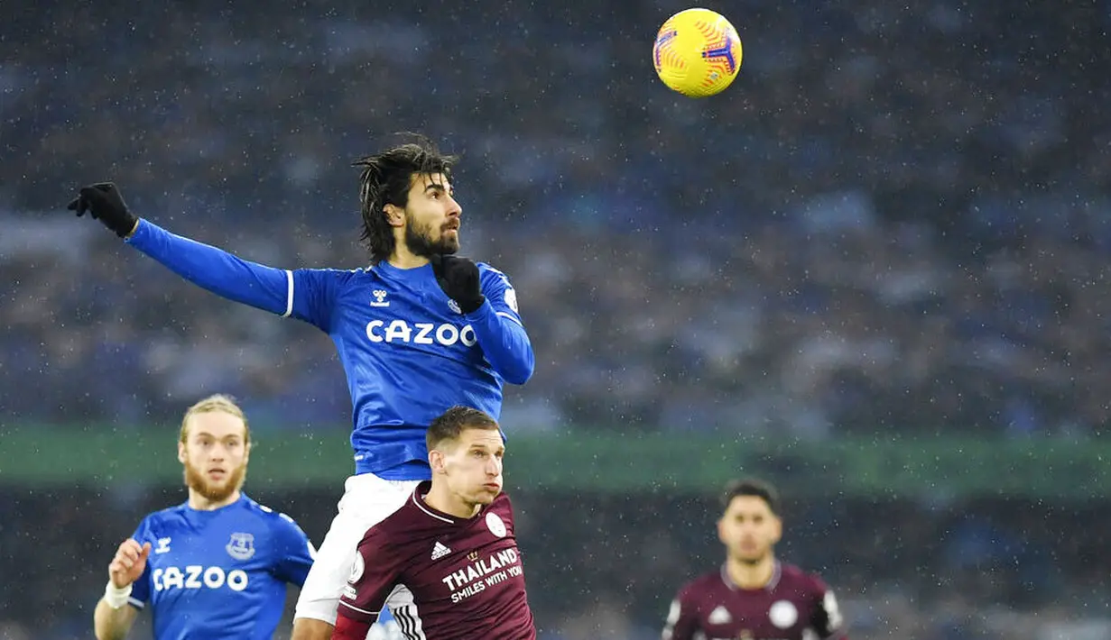 Pemain Everton, Andre Gomes duel udara dengan pemain Leicester City, Marc Albrighton, pada laga Liga Inggris di Stadion Goodison Park, Rabu (27/1/2021). Kedua tim bermain imbang 1-1. (Paul Ellis/Pool via AP)