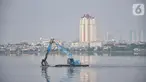 Petugas Suku Dinas Sumber Daya Air Jakarta Utara menggunakan kendaraan alat berat saat membersihkan lumpur Waduk Pluit, Senin (13/6/2022). Pengerukan lumpur rutin ini dilakukan sebagai upaya mengurangi endapan serta tanaman liar dan mencegah banjir di kawasan tersebut. (merdeka.com/Iqbal S Nugroho)